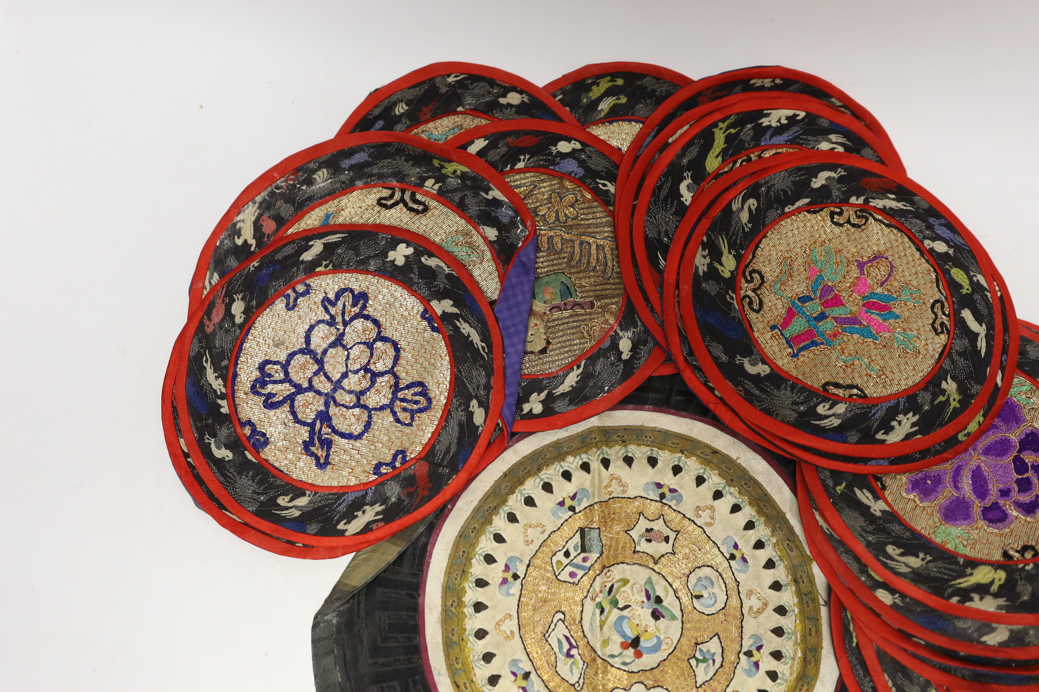 Three sets of six circular Chinese polychrome and gilt thread embroidered mats, a set of four mats and seven other similar various sized embroidered mats, (29)